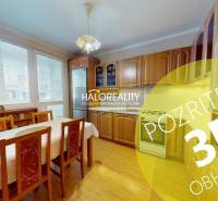 Küche in einer 2-Zimmer-Wohnung mit hellem Holzdekor und Esstisch.