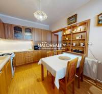 Küche in einer 2-Zimmer-Wohnung mit Esstisch und Boden in Holzoptik.