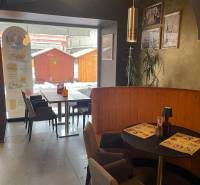 Gastronomiebereiche mit Café-Sitzgelegenheiten, Wanddekorationen und Blick auf die Holzstände draußen.