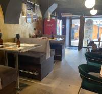 Innenraum eines Gastronomiebereichs mit bequemen Sitzgelegenheiten und dekorativen Leuchten.