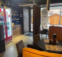 Innenraum von Gastronomiebereichen mit rundem Tisch, Stühlen und Beleuchtung.