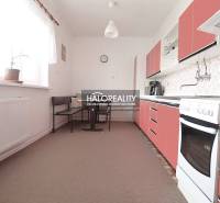 Eine Küche in einem Einfamilienhaus mit roten Schränken und einem Essbereich.