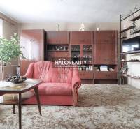 Wohnzimmer in einem Einfamilienhaus mit rotem Sofa und Holzwohnwand.