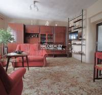 Wohnzimmer in einem Einfamilienhaus mit Sesseln, Vitrine und Teppich.