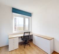 Arbeitszimmer mit Eckschreibtisch, blauen Schränken und Boden in Holzoptik in einer 4-Zimmer-Wohnung.