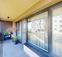 Balkon in Bratislava - Lamač mit Aussicht, großen Fenstern und Blumendekoration.