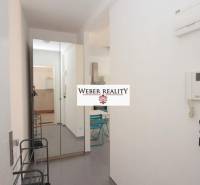 Flur in einer 2-Zimmer-Wohnung mit Garderobe, Spiegel und Fliesen.