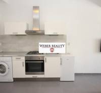 Küche in einer 2-Zimmer-Wohnung mit Geräten und Fernseher an der Wand.