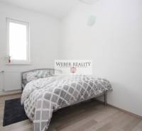 Schlafzimmer in einer 2-Zimmer-Wohnung mit Bett und Boden in Holzoptik.