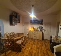 Innenraum eines Einfamilienhauses mit Holzboden, großem Tisch und Dekorationen.