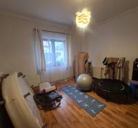 Fitnessstudio im Einfamilienhaus mit Trainingsgeräten und Boden in Holzoptik.