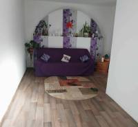 Wohnzimmer in einem Einfamilienhaus mit violettem Sofa und Holzboden.