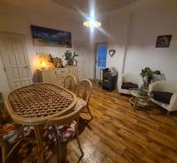 Innenraum eines Einfamilienhauses mit Holzboden, einem Korbtisch und bequemen Sesseln.