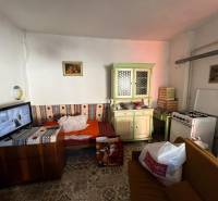 Ein Zimmer mit Sofa, Küchenzeile, Herd und Fernseher in einem Einfamilienhaus.