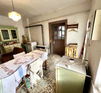 Esszimmer in einem Einfamilienhaus mit einem Kachelofen, einem Tisch und alten Möbeln.