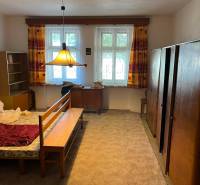 Ein Schlafzimmer in einem Einfamilienhaus mit Teppichboden und Möbeln in hellen Farben.