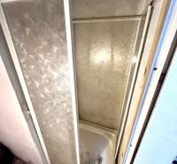 Duschkabine im Innenraum eines Einfamilienhauses mit Fliesen und dekorativem Boden.