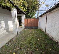 Der Hof des Einfamilienhauses in Jablonec mit Steinpflaster und Grünflächen.