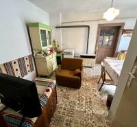 Wohnzimmer in einem Einfamilienhaus mit rustikalen Möbeln und gemustertem Boden.