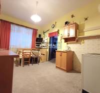 Küche in einem Einfamilienhaus mit Holzdekor, helle Wände, Tisch mit Stühlen.