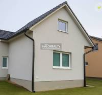Ein Einfamilienhaus in Kľačno mit weißer Fassade und schrägem Dach auf einem gepflegten Rasen.