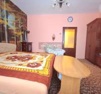 Ein Schlafzimmer in einem Einfamilienhaus mit einer Waldtapete und klassischen Holzmöbeln.