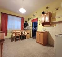 Eine Küche in einem Einfamilienhaus mit Holzelementen, einem Esstisch und Schränken.