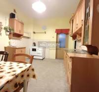 Küche in einem Einfamilienhaus mit Esstisch und Holzschränken.