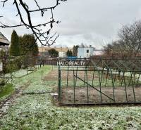 Ein Garten bei einem Einfamilienhaus in Prievidza mit Rasen und einer Konstruktion zum Anbau.