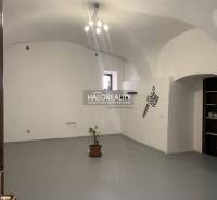 Innenräume von Büros mit weißen Wänden, gewölbter Decke und einer Pflanze im Blumentopf.