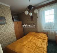 Schlafzimmer in einer 3-Zimmer-Wohnung mit Retro-Tapete und Fernseher.