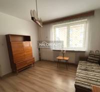 Wohnzimmer in einer 3-Zimmer-Wohnung mit Holzboden, Sofa, Schrank und Fenster.