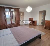 Ein Einfamilienhaus in Poprad ist von einem Garten, einem steinernen Gehweg und einem Zaun aus Holzlatten umgeben.