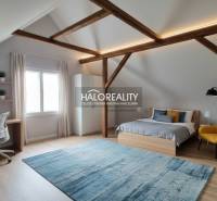 Schlafzimmer in einem Einfamilienhaus, Bett, Kommode und Boden mit Holzdekor.