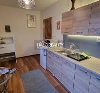 Dachzimmer in einem Einfamilienhaus mit Holzbalken und einem Boden in Holzoptik.