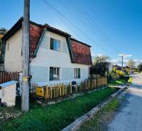 Ein Einfamilienhaus in Brodzany mit einem Holzzaun und einem gepflegten Garten in einer ruhigen Straße.