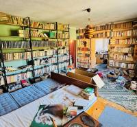 Eine Bibliothek in einem Einfamilienhaus mit vielen Büchern und einem Boden in Holzoptik.