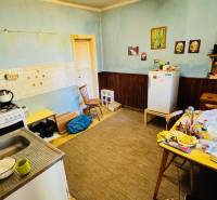 Küche in einem Einfamilienhaus mit Esstisch, älterem Herd und Kühlschrank.