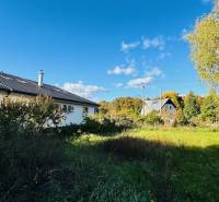 Ein Einfamilienhaus in Brodzany, umgeben von Grün und klarem blauen Himmel.