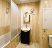 Badezimmer mit Badewanne, Waschbecken und Toilette in einer 3-Zimmer-Wohnung mit hellen Fliesen.