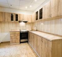 Küche in einer 3-Zimmer-Wohnung mit Holzdekor-Schränken und Fliesenboden.