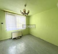 Ein Zimmer mit einem Kronleuchter, einem Fenster und einem Heizkörper in einer 3-Zimmer-Wohnung.