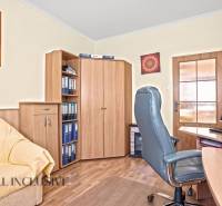 Arbeitszimmer in einem Einfamilienhaus mit Bürostuhl und Boden in Holzoptik.