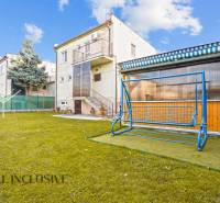 Der Garten des Einfamilienhauses in Dunajská Streda mit einer Schaukel und grünem Rasen.