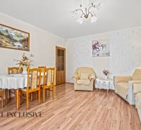 Wohnzimmer in einem Einfamilienhaus, Boden mit Holzdekor, Esstisch, Sessel, Bilder.