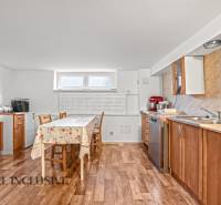 Küche in einem Einfamilienhaus mit Holzboden, Naturholzschränken, hellem Tisch.