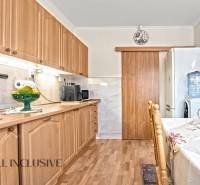 Eine Küche in einem Einfamilienhaus mit einem Boden in Holzoptik und Holzmöbeln.