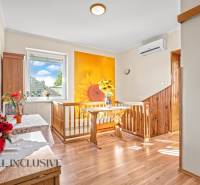 Ein Einfamilienhaus mit einer Wand mit Sonnendekor, einem Boden mit Holzdekor und einer Vase mit Blumen.