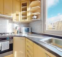 Küche in einer 3-Zimmer-Wohnung mit Holzschränken, Gasherd und Blick aus dem Fenster.