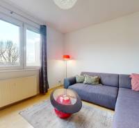 Obývacia izba v 3-izbovom byte s veľkými oknami, pohovkou a stolíkom.

Wohnzimmer in einer 3-Zimmer-Wohnung mit großen Fenstern, einem Sofa und einem Tisch.